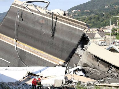 Bomberos y personal de rescate, junto a los restos del puente caído.