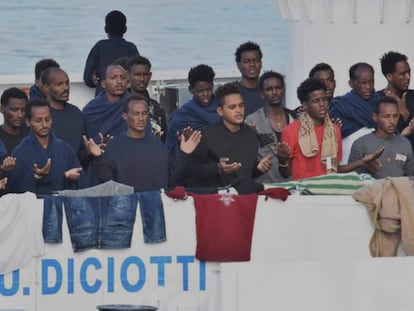 Migrantes rezan este miércoles a la espera del desembarco de la patrullera 'Diciotti' en Catania (Italia). En vídeo, las imágenes de los 177 inmigrantes.