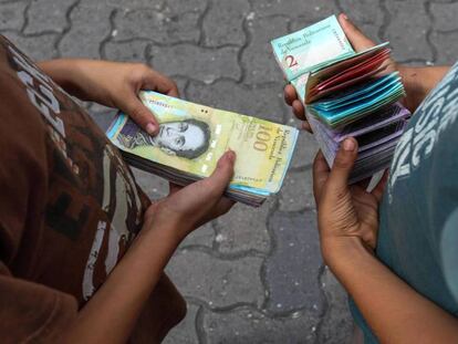 Dos niños cuentan billetes en Caracas.