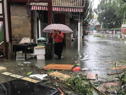 Un hombre se protege del agua en el pueblo pesquero de Lei Yu Mun en Hong Kong antes de la llegada de Mangkhut / En vídeo, la llegada del tifón Mangkhut a Hong Kong (REUTERS-QUALITY)