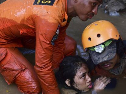 FOTO: Un equipo de búsqueda y rescate ayudan a una joven atrapada en su vivienda. / VÍDEO: La devastación del tsunami, a vista de dron