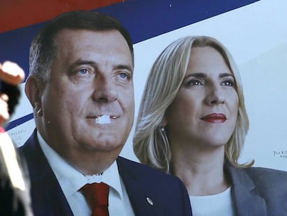 Un hombre, ante un cartel electoral con las imágenes del presidente y la primera ministra serbobosnios, Milorad Dodik y Zeljka Cvijanovic, este viernes en la ciudad bosnia de Banja Luka / En vídeo, declaraciones de Milorad Dodik