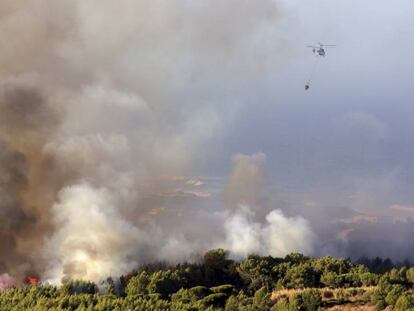 Un helicóptero echa agua al incendio en Charneca, en la sierra de Sintra, esta mañana.