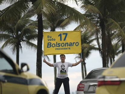 Un hombre muestra un cartel en la puerta de la casa de Bolsonaro. / En vídeo, nuevas protestas en Brasil contra Bolsonaro