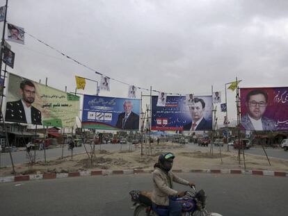 Un motorista frente a carteles de campaña de candidatos parlamentarios, este martes en Kabul / En vídeo, el arranque de los comicios en Afganistán (ATLAS)