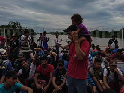 Un grupo de inmigrantes permanece sobre el puente fronterizo entre Guatemala y México.