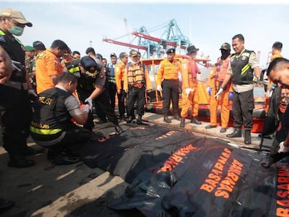 Miembros de los servicios de rescate trasladan los cuerpos de las víctimas del avión accidentado en Indonesia en el puerto Tanjung Priok en Yakarta.