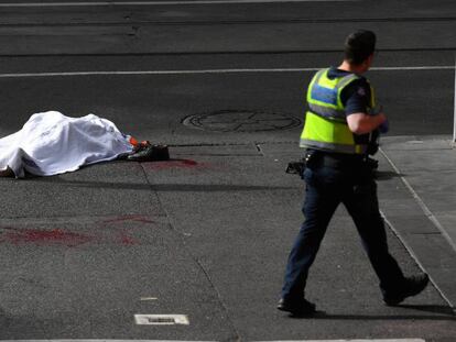 Un policía, junto al cadáver de una de las víctimas del ataque cubierto por una sábana en Melbourne.