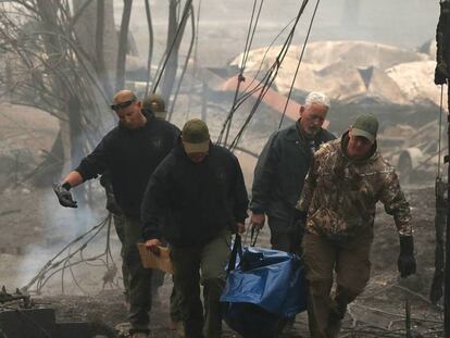 Agentes de policía retiran un cadáver recuperado de los escombros en Paradise, California. En vídeo, más de 30 fallecidos y 100 desaparecidos en el incendio que afecta a California.