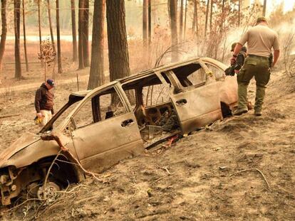 Agentes de policía inspeccionan este domingo un automóvil destruido por el fuego en Concow (California).