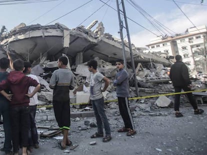 Palestinos inspeccionan los escombros tras un ataque aéreo israelí en una zona residencial de la franja de Gaza este martes 13 de noviembre.