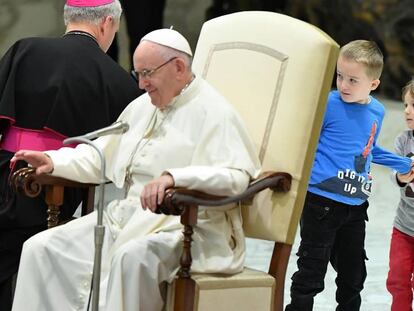 Un niño autista, junto a su hermana, en la audiencia general del Papa en el Vaticano.