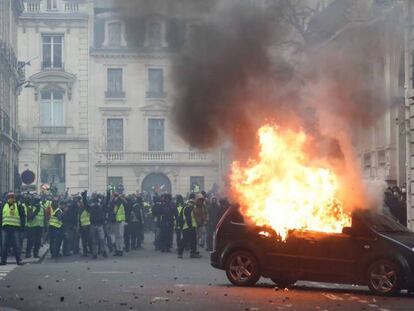 Un coche ardiendo en la protesta de los 'chalecos amarillos', cerca del Arco del Triunfo en París. En vídeo, más de 700 detenidos en una movilización de con más de 30.000 participantes.