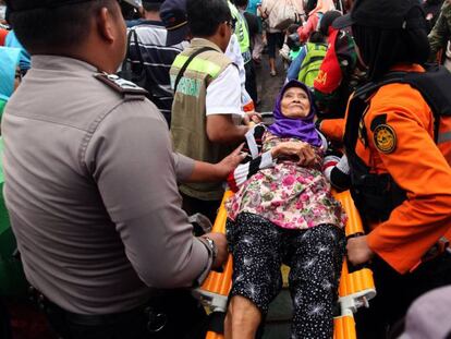 En foto, una mujer es evacuada este miércoles en la isla de Sebesi. En vídeo, supervivientes del tsunami que azotó Indonesia el sábado que viven en un pabellón adaptado como refugio.