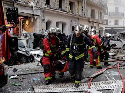 Los bomberos trasladan a los heridos, tras la explosión, este sábado, en una panadería del centro de París.