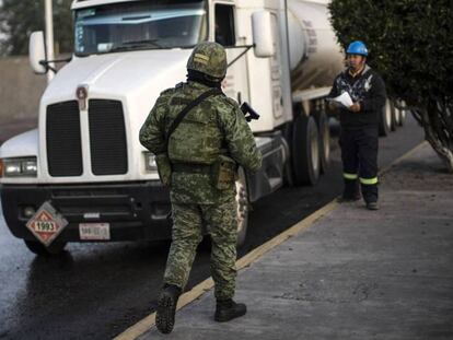 Un soldado supervisa los camiones de transporte de combustible, este viernes en Hidalgo. En vídeo, López Obrador defiende su plan contra el robo de combustibles.