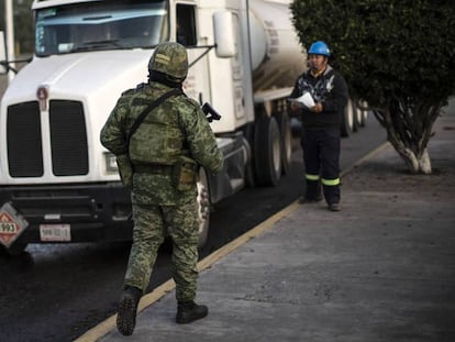 Un soldado supervisa los camiones de transporte de combustible, este viernes en Hidalgo. En vídeo, López Obrador defiende su plan contra el robo de combustibles.