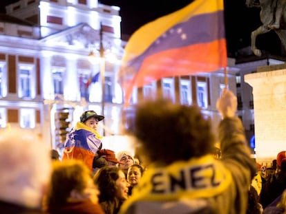 Un niño envuelto en la bandera venezolana en la Puerta del Sol de Madrid en la concentración en apoyo a Juan Guaidó. En vídeo, imágenes de la manifestación.