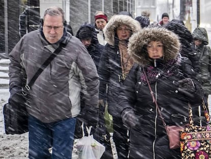 Peatones na rua Wacker Drive em Chicago, nesta segunda-feira. Em vídeo, imagens das nevadas em vários Estados do país.
