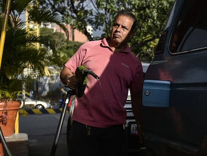 Un hombre echa gasolina en una estación de servicio de PDVSA en Caracas. En vídeo, el anuncio de las sanciones a Venezuela.