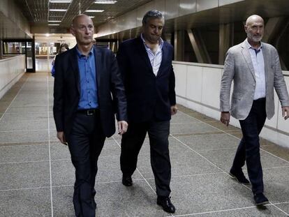 El embajador de España en Venezuela, Jesús Silva (centro), y el embajador de los Países Bajos en Venezuela, Norbert Braakuis (izquierda), salen este domingo con un agente de seguridad del Aeropuerto Internacional Simón Bolívar. En vídeo, Borrell condena que Caracas haya rechazado la entrada de eurodiputados conservadores.