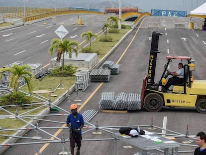 Trabajadores ensamblan la tarima del escenario que acogerá el concierto en el puente Simón Bolívar. En vídeo, declaraciones de Richard Branson, organizador del concierto pro Guaidó, y del ministro de Información de Maduro.