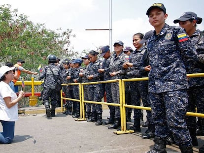 Una seguidora de Juan Guaidó se arrodilla frente a agentes de la Guardia Nacional Bolivariana. En vídeo, declaraciones de Guaidó.