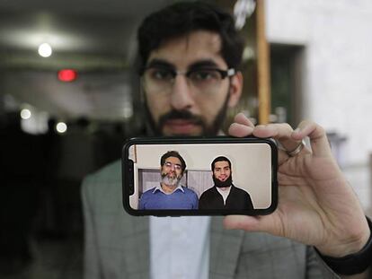 Un hombre muestra una fotografía de Naeem Rashid y su hijo Talha Naeem, dos de los nueve paquistaníes asesinados en el atentado de Christchurch, este lunes en Lahore (Pakistán).