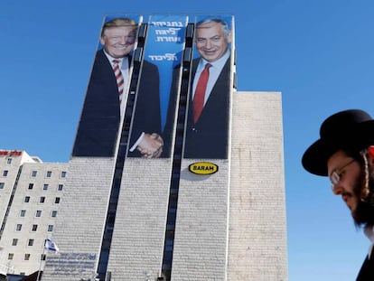 Un judío ultraortodoxo pasa ante un cartel con la imagen de Trump y Netanyahu, en febrero en Jerusalén. En vídeo, Trump explica por qué ha reconocido el Golán como territorio de Israel en una entrevista en Fox News.