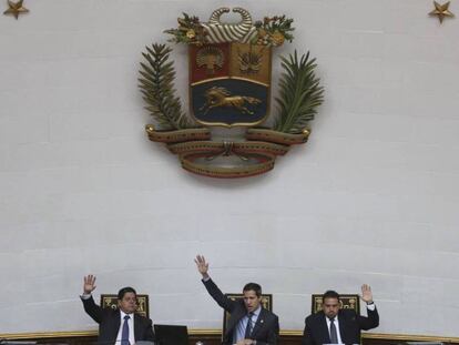 Juan Guaidó (centro) alzan sus manos en una sesión de la Asamblea Nacional venezolana.