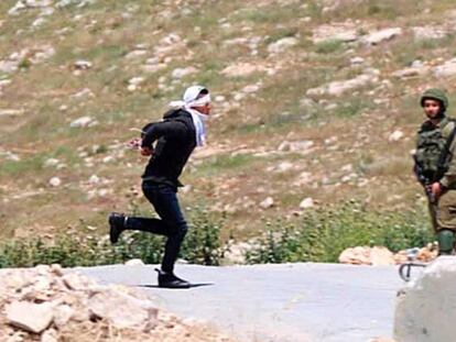 El joven palestino Osama Hajajra huye maniatado de tropas israelíes, el jueves en Cisjordania, antes de ser herido.