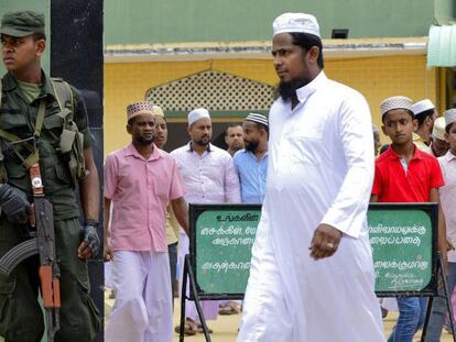 Un soldado custodia la entrada a una mezquita de Kattankudy (Sri Lanka) durante el rezo del viernes. En vídeo, la Policía de Sri Lanka halla material para elaborar bombas y uniformes del ISIS.