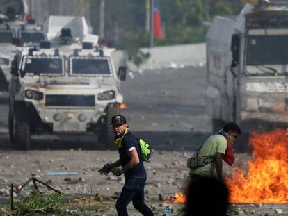 Opositores de Maduro frente a tanquetas militares, este miércoles.