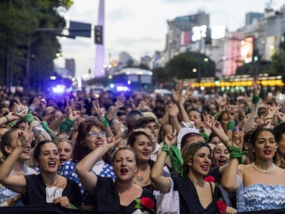 Las mujeres caracterizadas de Evita marchan frente del obelisco.