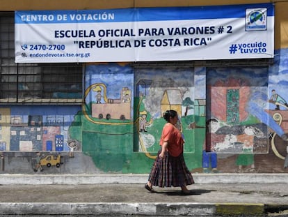 Una mujer camina ante un centro de votación en Ciudad de Guatemala.