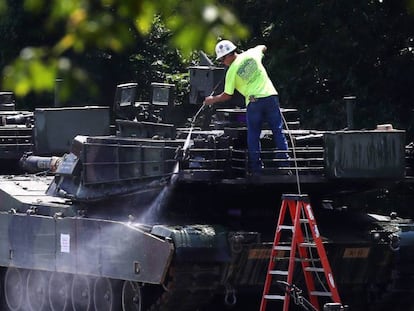 Un trabajador limpia uno de los dos tanques M1A1 Abrams.