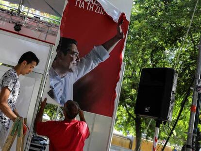 Dos operarios retiran publicidad electoral de Syriza este lunes en Atenas. En vídeo, así fue la despedida de Tsipras.