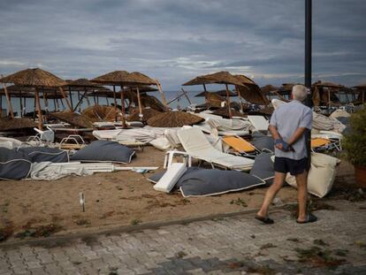 Un hombre observa un caos de hamacas y sombrillas en Nea Plagia. En vídeo, imágenes de los destrozos del temporal.