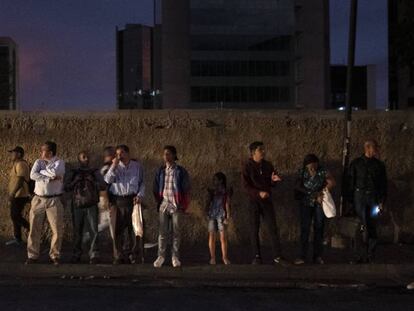 Peatones esperan el autobús que los llevaría a la urbanización El Cafetal, en Caracas.