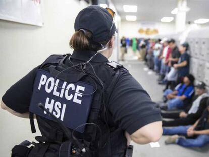 Una agente vigila a inmigrantes detenidos en una redada masiva el miércoles en Misisipi (EE UU).