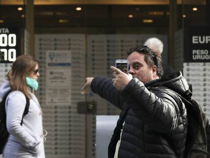 Un hombre se hace un selfi frente a una casa de cambio, este lunes en Buenos Aires.