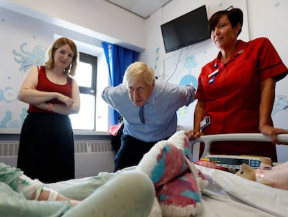 El primer ministro británico, Boris Johnson, el lunes con una paciente de cinco años durante su visita a un hospital en Truro (Inglaterra).