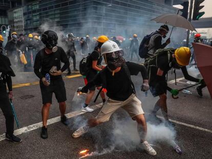 Manifestantes responden a los gases lacrimógenos lanzados por la policía este sábado en Hong Kong. En vídeo, imágenes de los enfrentamientos.