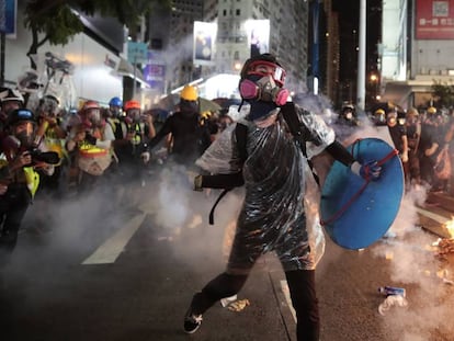 Manifestante com máscara de gás na manifestação proibida deste sábado em Hong Kong. Em vídeo, imagens dos protestos.