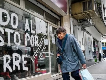 Mulher passa diante de loja em liquidação no dia 22 de agosto, em Buenos Aires. Em vídeo, imagens dos protestos na Argentina.