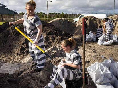 Varias mujeres presas en la cárcel del condado de Brevard llenan sacos de arena para los residentes de Cocoa (Florida) ante la inminente llegada del huracán Dorian.