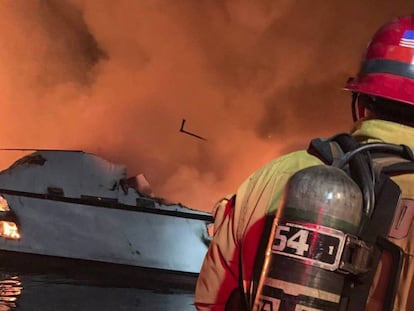 Un bombero trata de extinguir el incendio del barco en California.