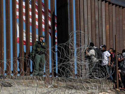 Inmigrantes en la valla fronteriza de Tijuana, México.