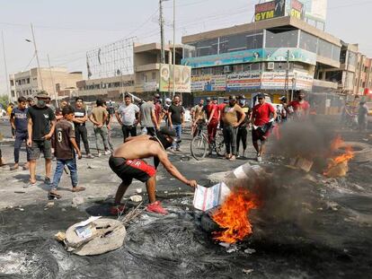 Manifestantes queman neumáticos en una calle de Bagdad durante el toque de queda este jueves. En vídeo, crónica de las protestas.