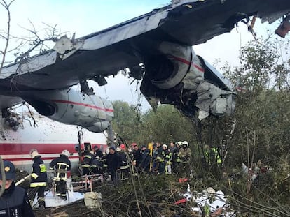 Miembros de los equipos de rescate trabajan alrededor del avión siniestrado en Ucrania este viernes.